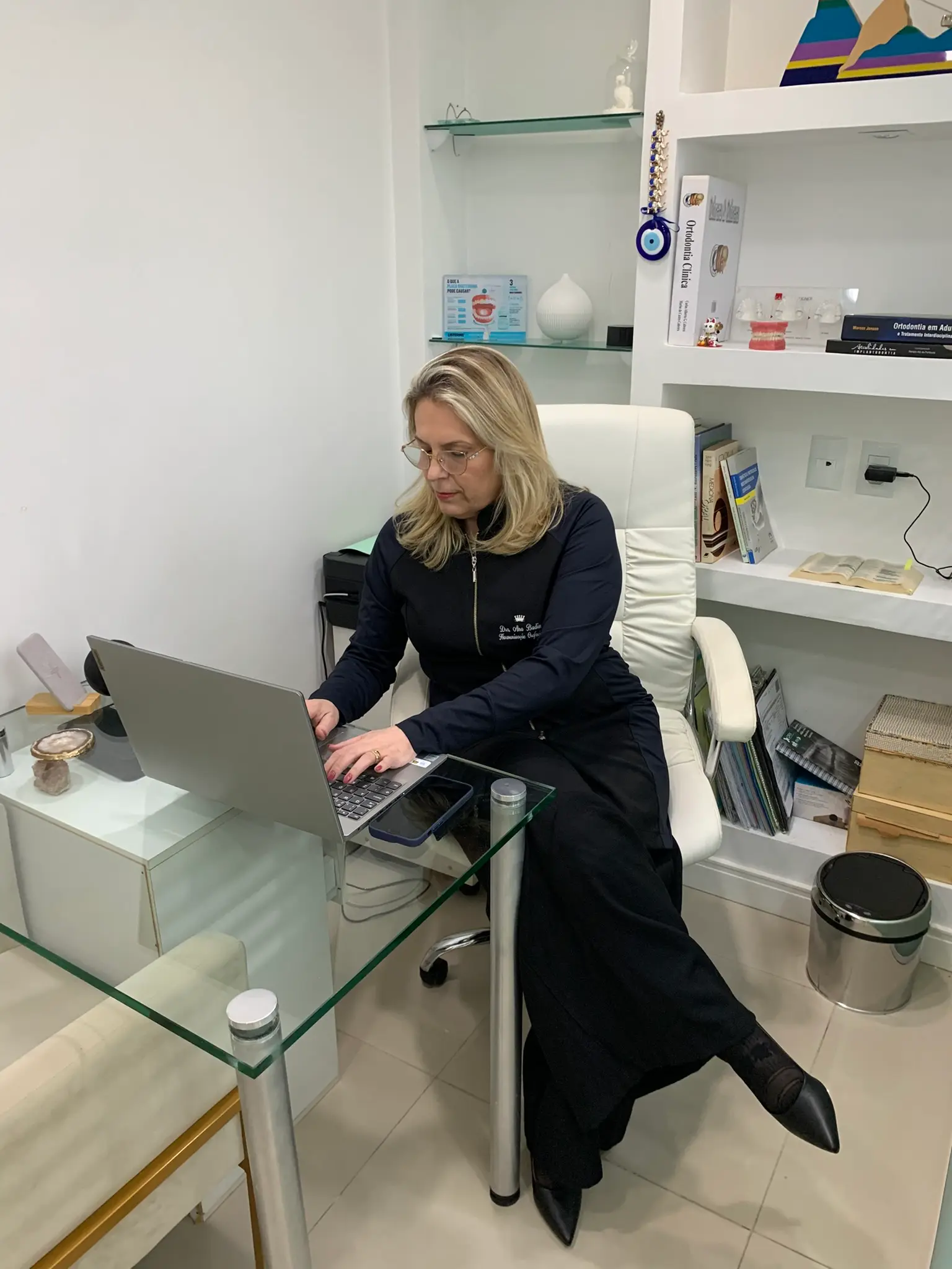 Dra. Ana C. Badin planejando um caso no computador do consultório