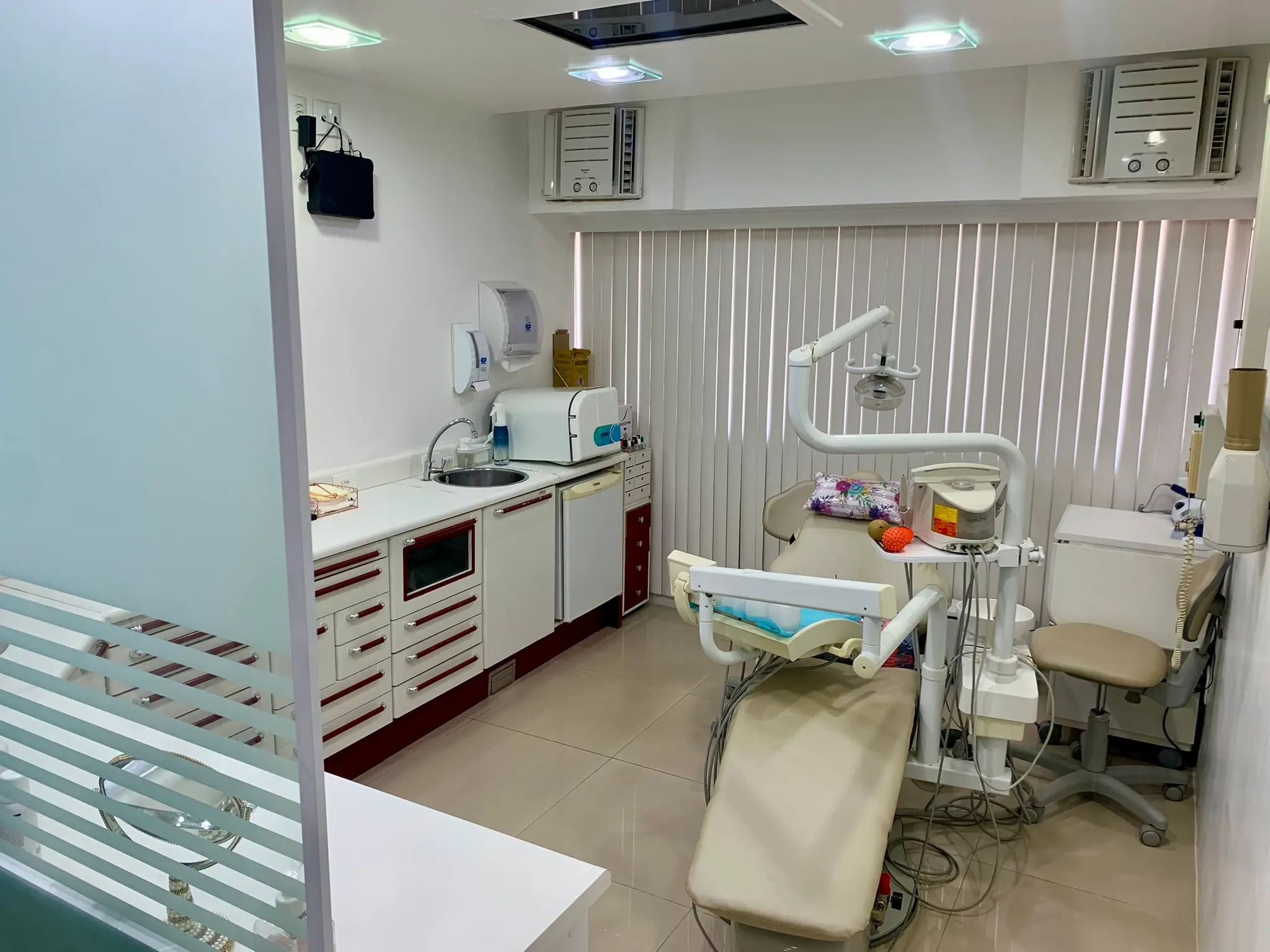 Sala clínica com cadeira odontológica e equipamentos